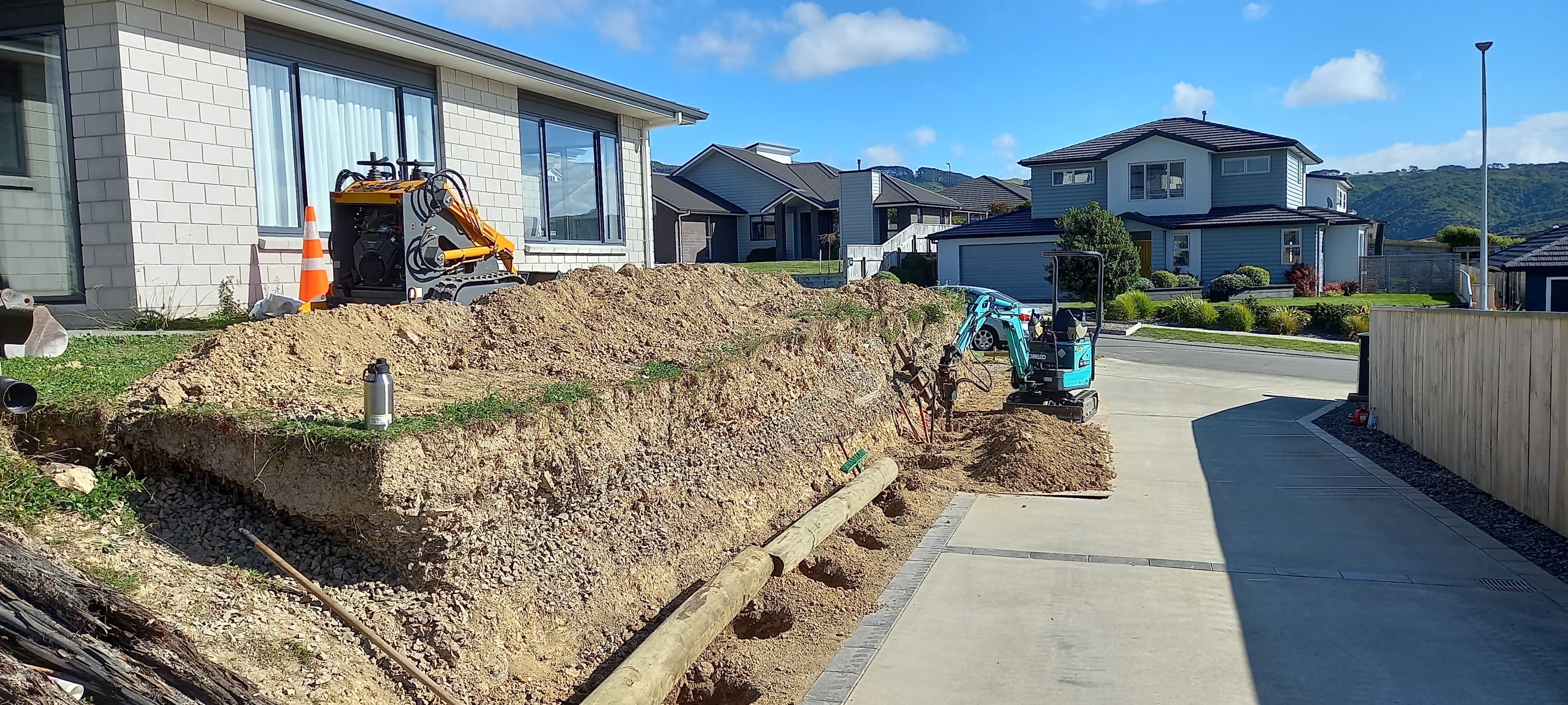 Excavation and trenching along the wall line for a timber pole retaining wall in Wellington